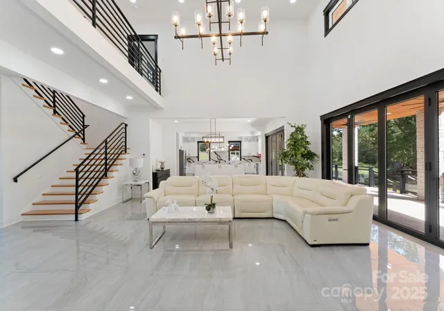 a living room with furniture ceiling fan and a large window