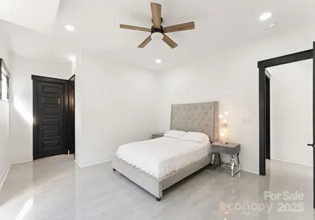 a bedroom with a bed and a ceiling fan