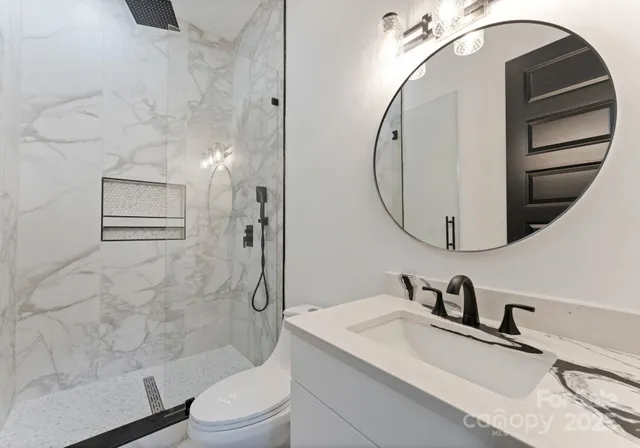 a bathroom with a sink a toilet and shower