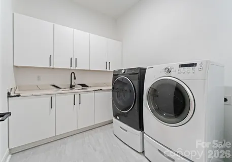 a utility room with sink dryer and washer