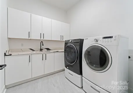 a utility room with sink dryer and washer
