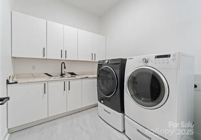 a utility room with sink dryer and washer
