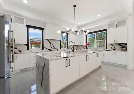 a view of counter top space with hallway and chandelier