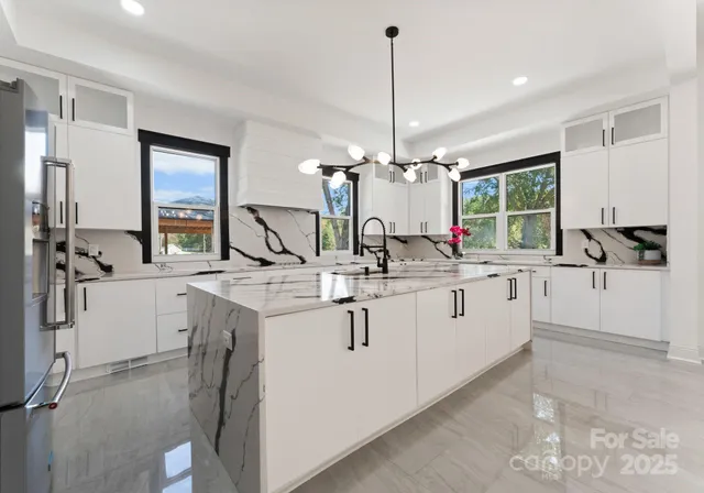 a view of counter top space with hallway and chandelier
