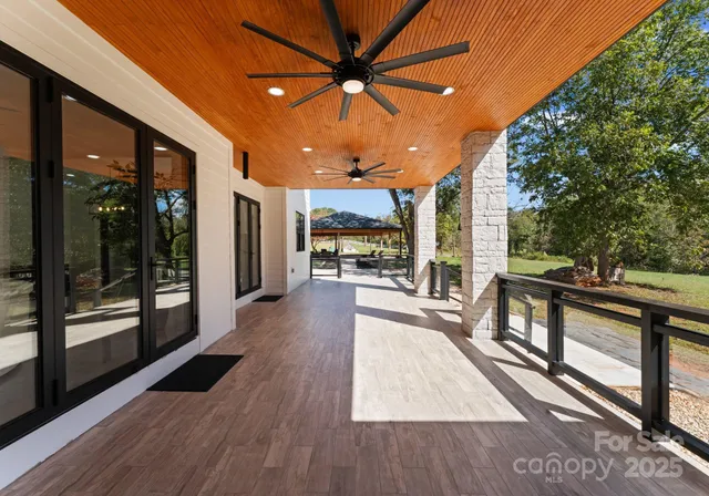 a view of a patio with wooden floor and iron fence