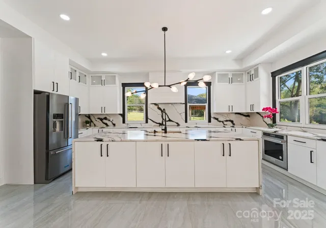 a kitchen with stainless steel appliances granite countertop a sink and refrigerator