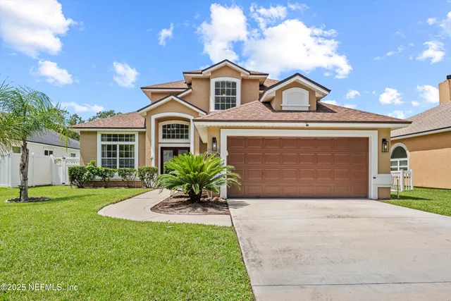 a front view of a house with a yard and garage
