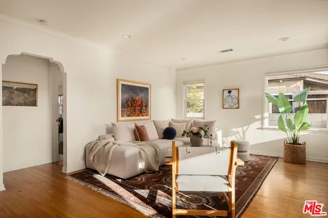 a living room with furniture and wooden floor