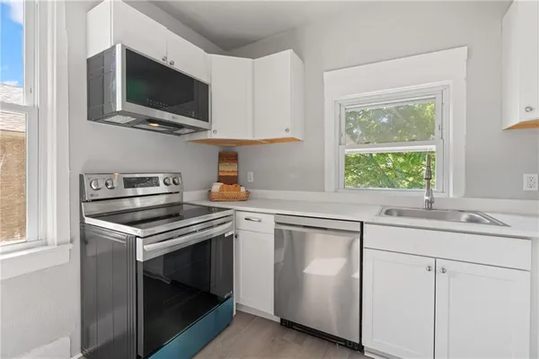 a kitchen with cabinets stainless steel appliances and a sink
