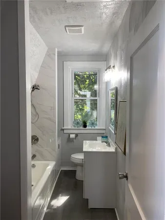 a bathroom with a tub a sink and a large mirror
