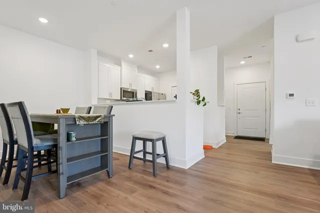 a kitchen with a sink stainless steel appliances and wooden floor