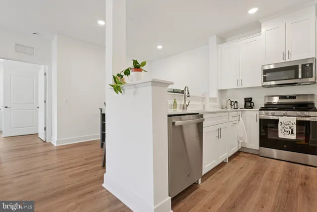 a kitchen with white cabinets and white appliances