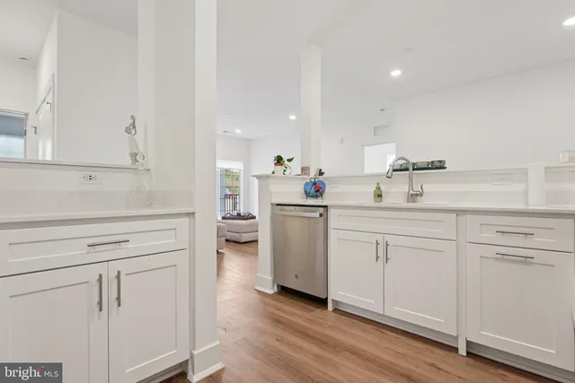 a kitchen with stainless steel appliances granite countertop a sink dishwasher stove and microwave with wooden floor