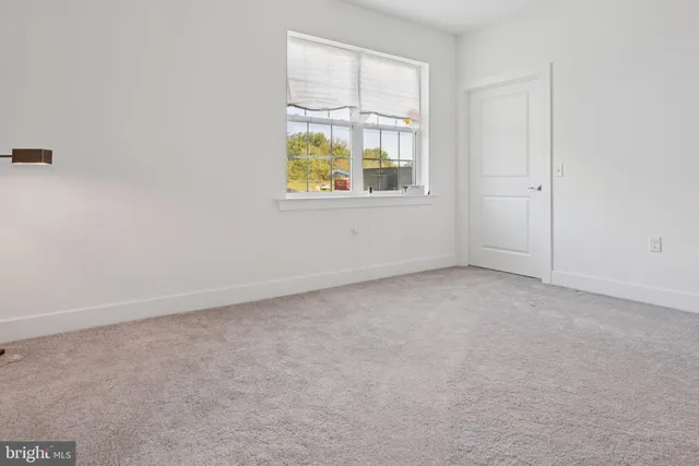 a spacious bedroom with a bed and painting on the wall