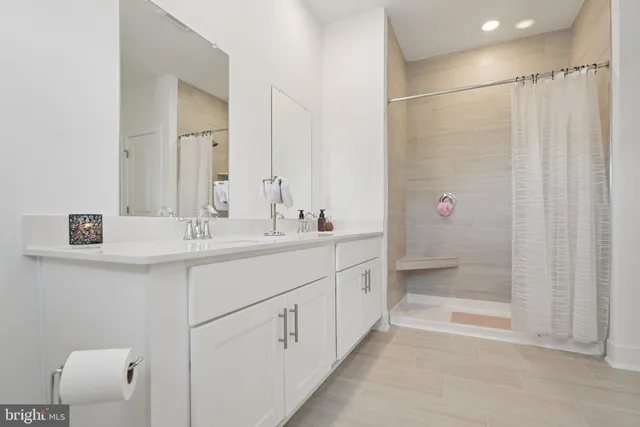 a bathroom with a shower a mirror and a sink