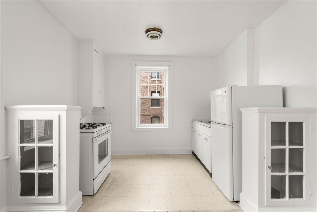 97 Chester Street, Unit 8 Boston, MA 02134 - Photo 4 of 19 a view of a kitchen with white cabinets and window