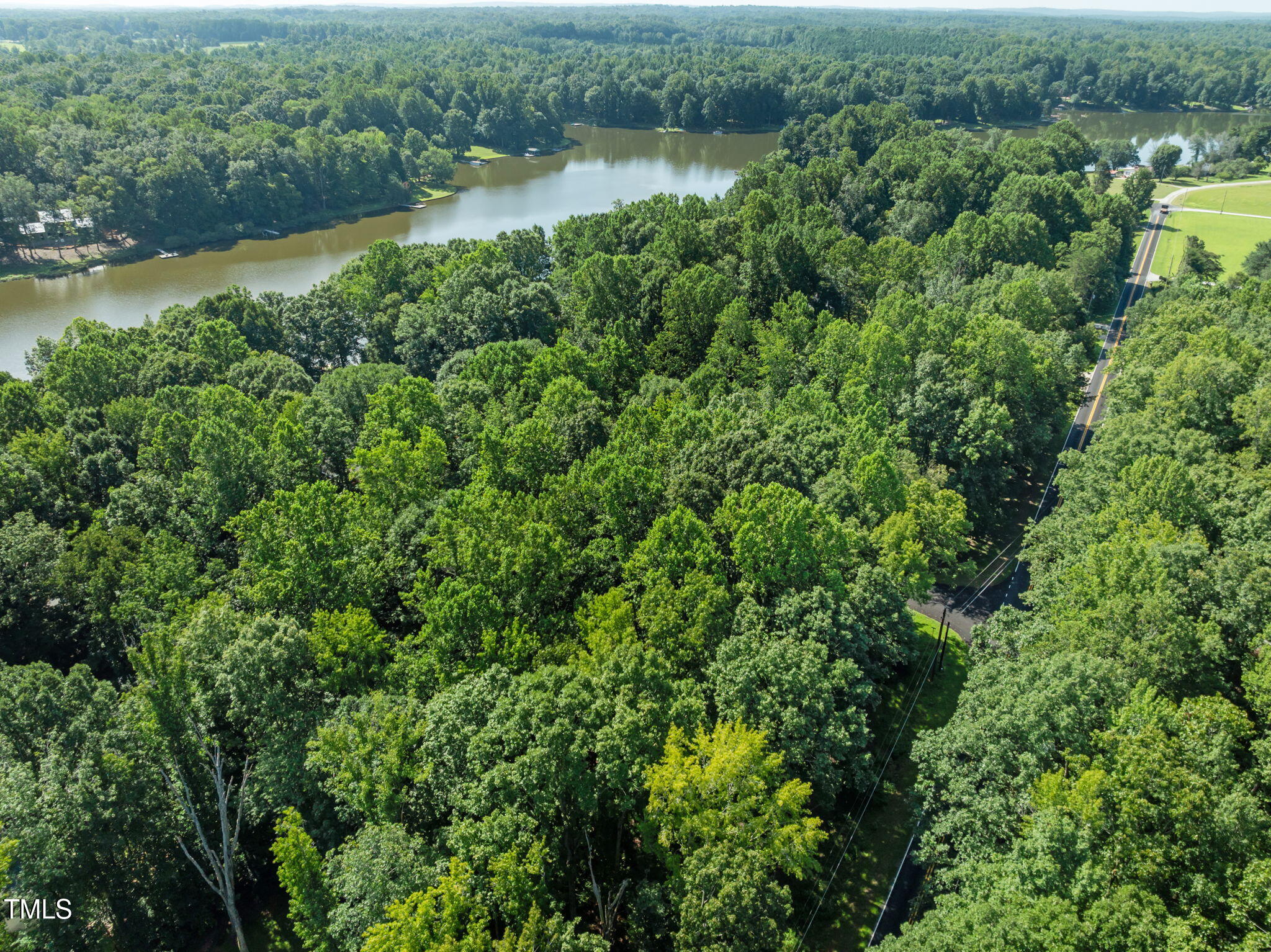 605 Canotage Court Cedar Grove, NC 27231 - Photo 12 of 17 an aerial view of green landscape with trees houses and lake view