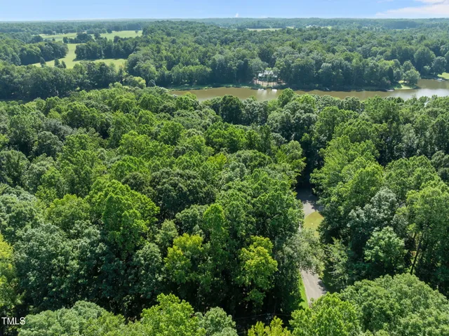 an aerial view of residential house with outdoor space and trees all around