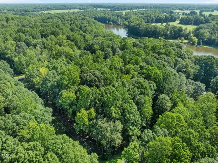 an aerial view of a house with a lush green forest