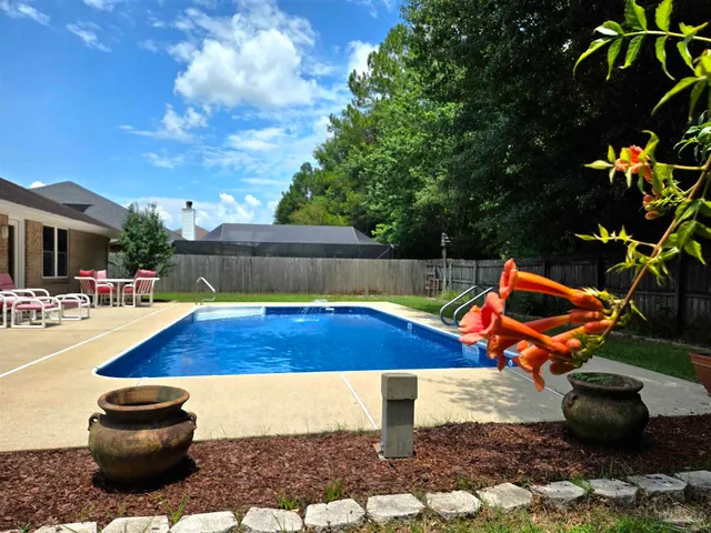 a view of a backyard with swimming pool