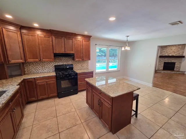 a view of empty room with wooden floor and a fireplace