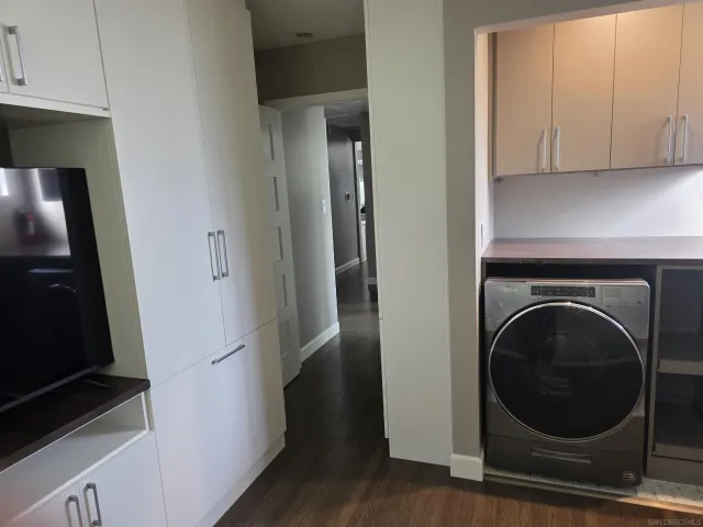 an empty room with wooden floor closet and windows