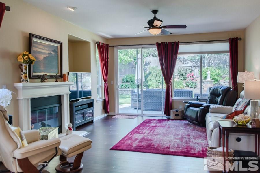 14070 Tagor Drive Reno, NV 89521 - Photo 3 of 24 a living room with furniture a fireplace a large window and a flat screen tv