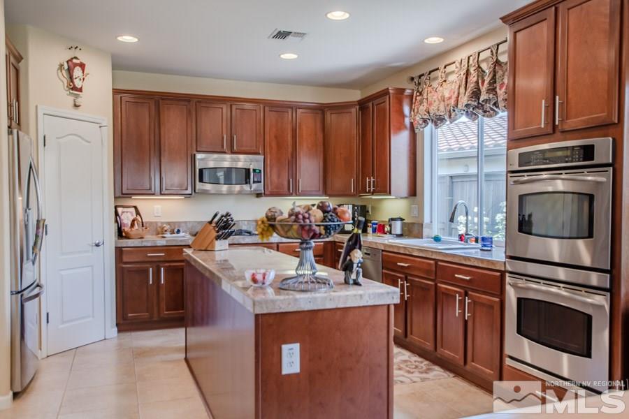 14070 Tagor Drive Reno, NV 89521 - Photo 6 of 24 a kitchen with granite countertop a sink stove and refrigerator