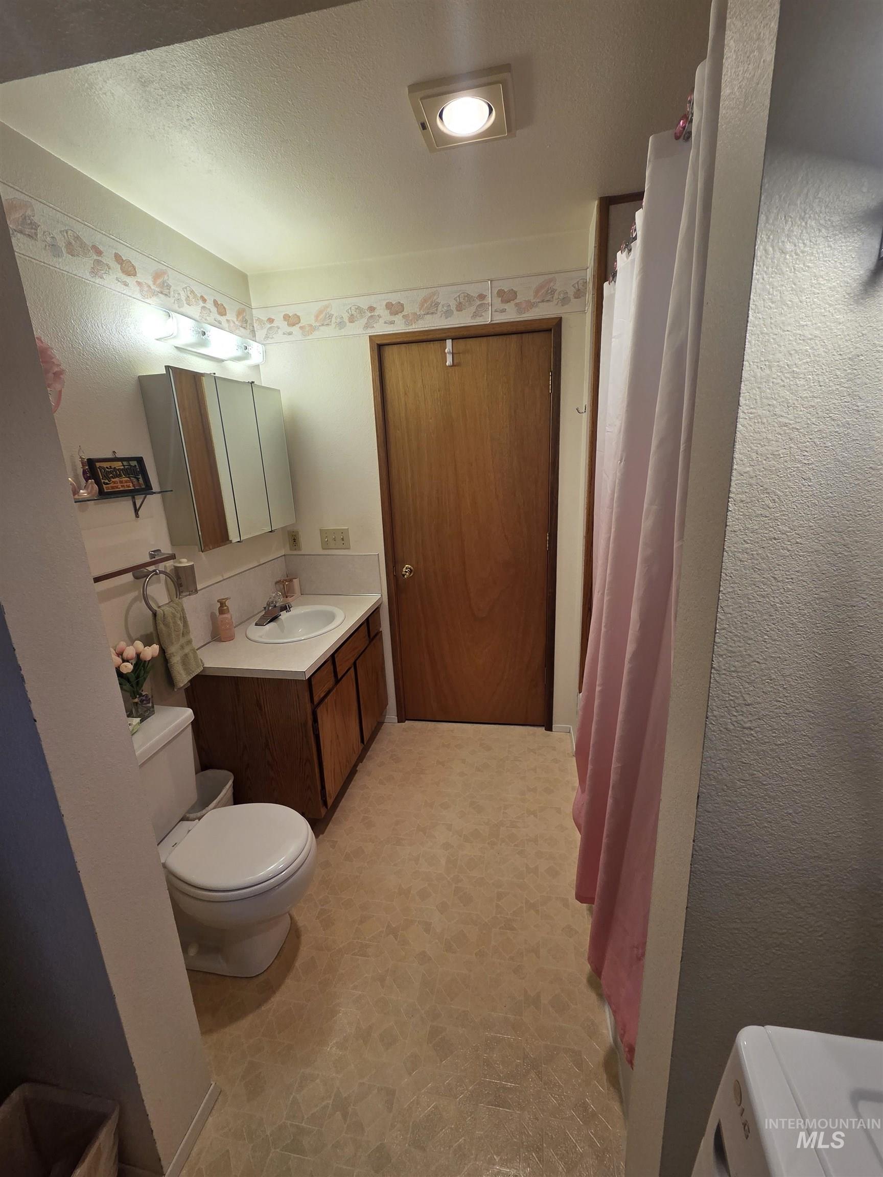 1607 Main Street Pomeroy, WA 99347 - Photo 12 of 28 Full bathroom featuring vanity, a shower with curtain, a textured ceiling, and a textured wall