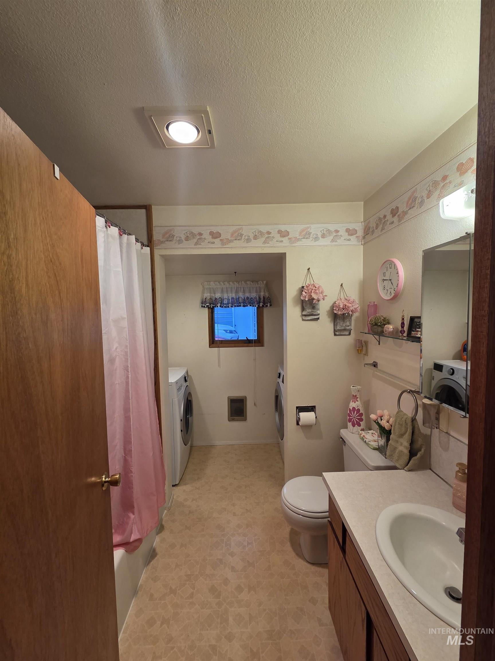 1607 Main Street Pomeroy, WA 99347 - Photo 13 of 28 Full bathroom featuring a textured ceiling, vanity, light flooring, washer / dryer, and shower / bath combination with curtain