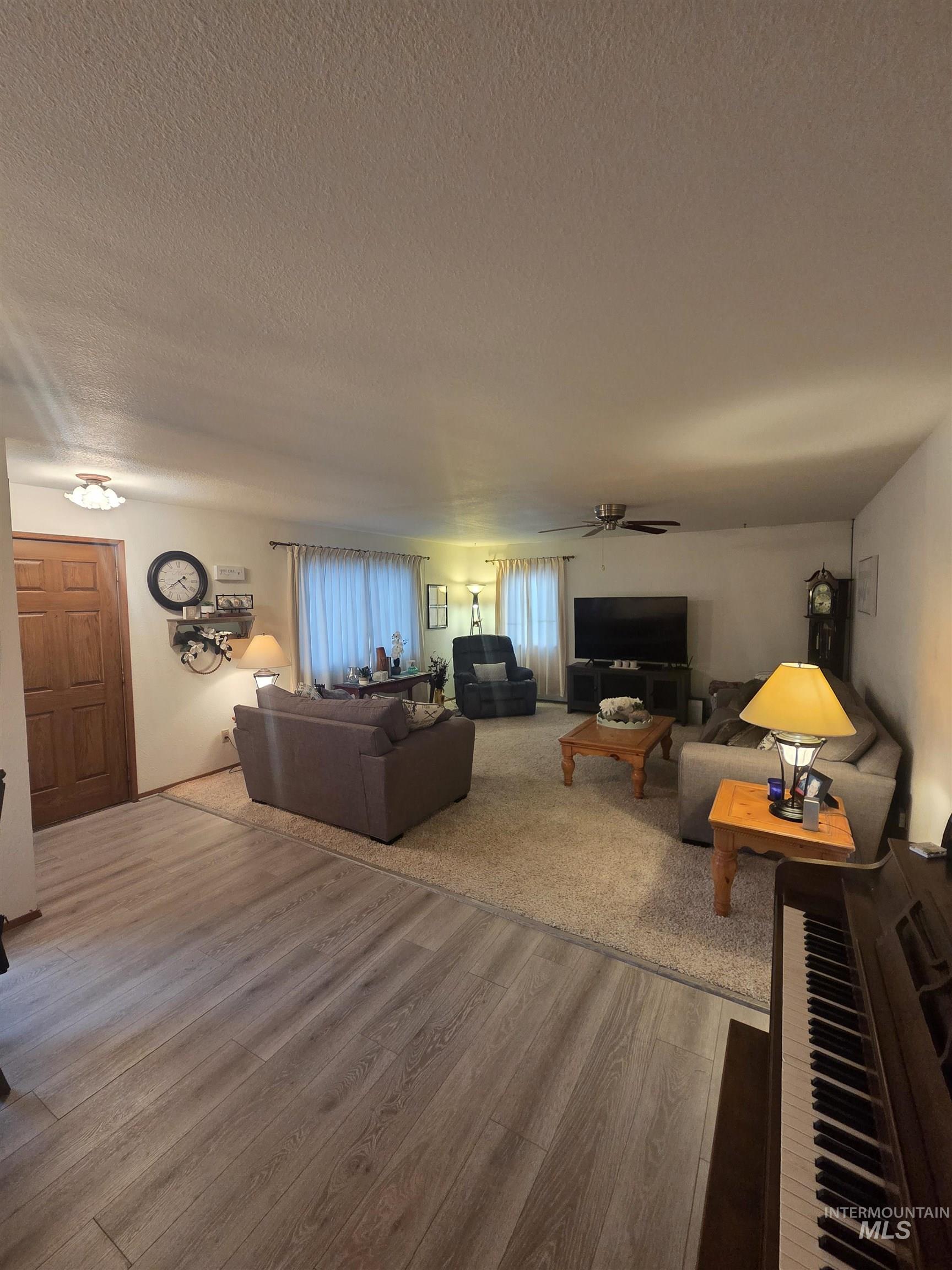 1607 Main Street Pomeroy, WA 99347 - Photo 4 of 28 Living room with wood finished floors, a ceiling fan, and a textured ceiling