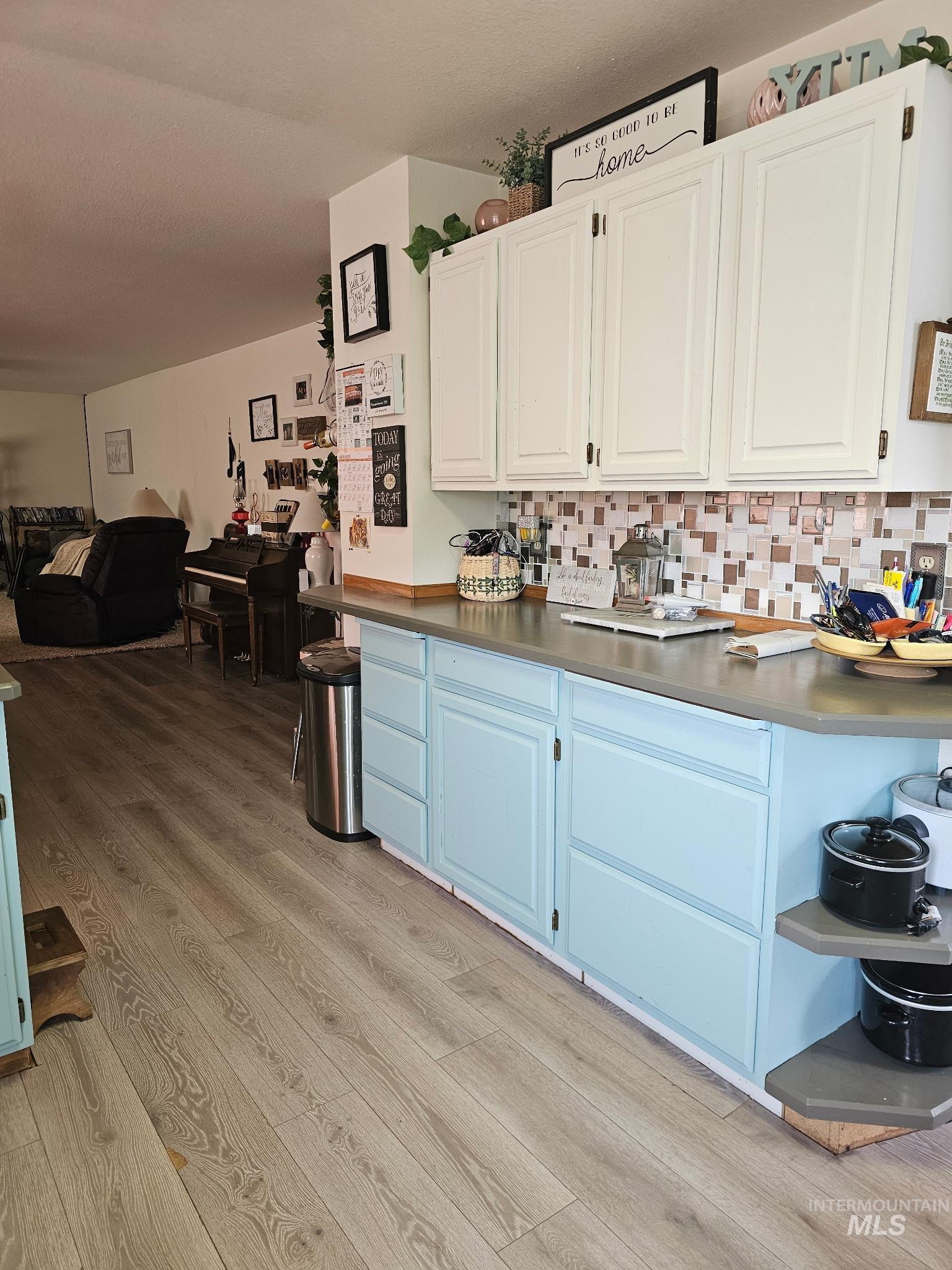 1607 Main Street Pomeroy, WA 99347 - Photo 28 of 28 Kitchen featuring open floor plan, light wood finished floors, white cabinetry, and tasteful backsplash
