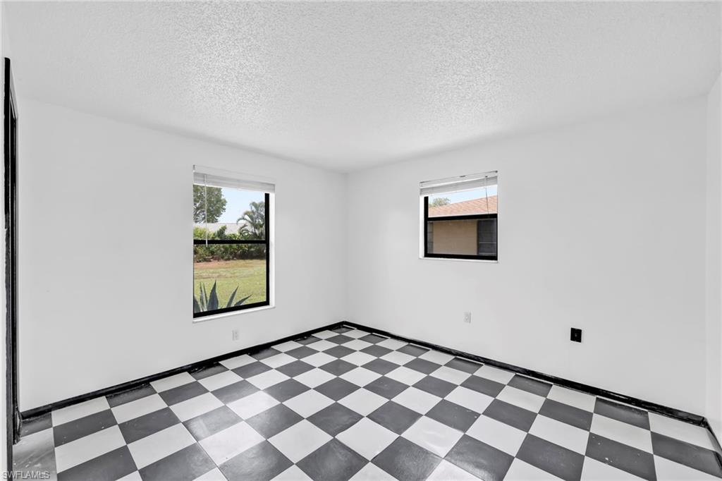 140 Blue Ridge Drive Naples, FL 34112 - Photo 12 of 26 Unfurnished room featuring tile patterned floors, a textured ceiling, and baseboards