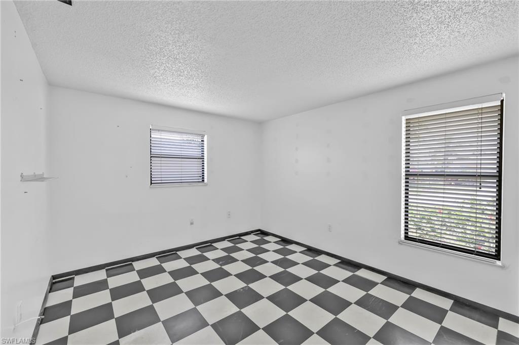 140 Blue Ridge Drive Naples, FL 34112 - Photo 17 of 26 Spare room with tile patterned floors and a textured ceiling
