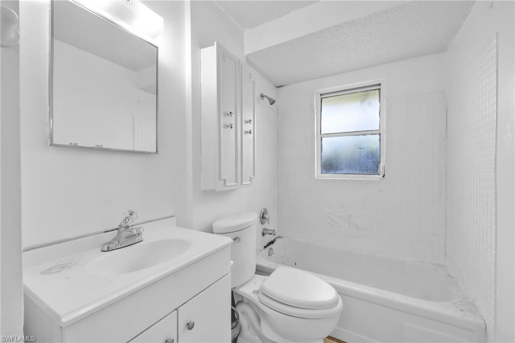 140 Blue Ridge Drive Naples, FL 34112 - Photo 21 of 26 Full bath featuring toilet, vanity, shower / bath combination, and a textured ceiling