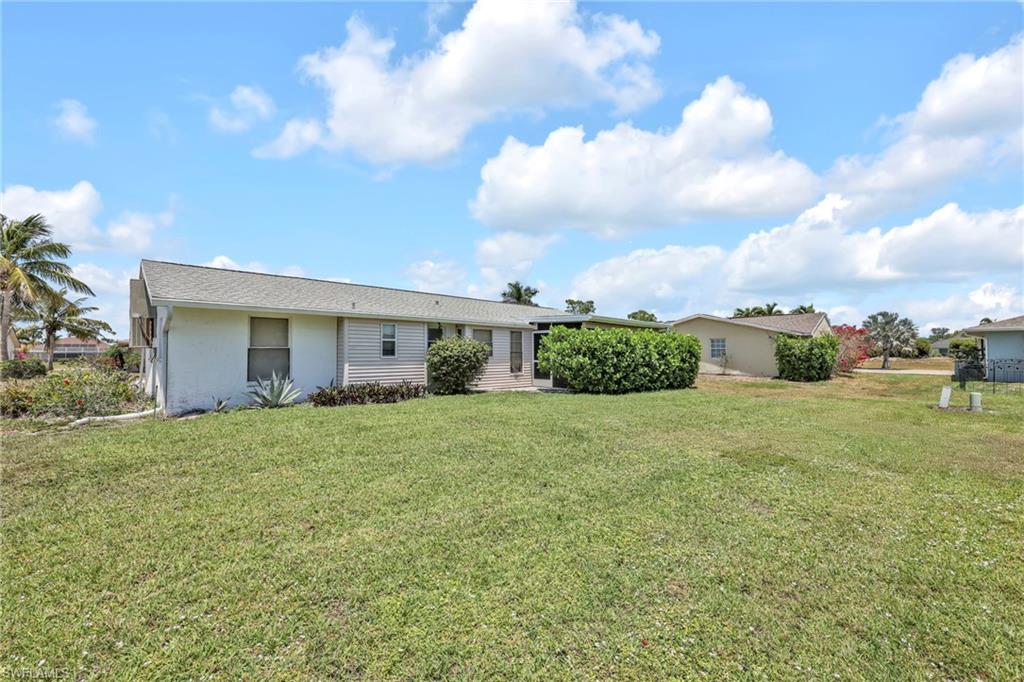 140 Blue Ridge Drive Naples, FL 34112 - Photo 25 of 26 Back of property with a yard and stucco siding