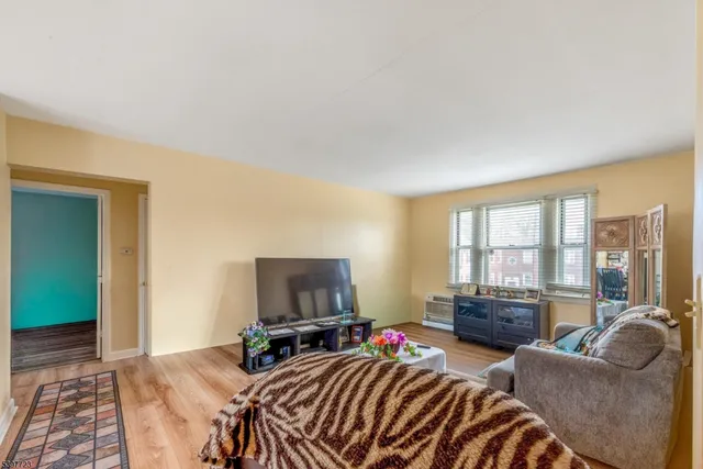 a bedroom with furniture a flat screen tv and a large window