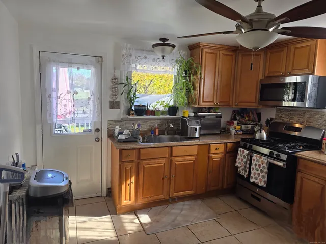 a kitchen with stainless steel appliances granite countertop a dining table and chairs