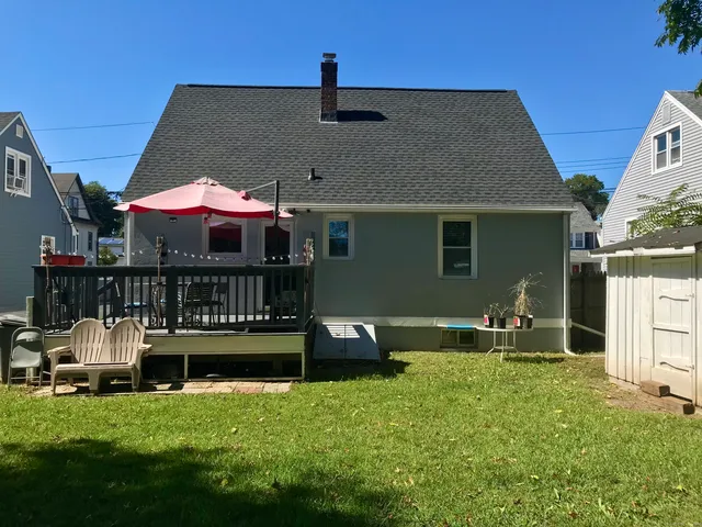 a view of a house with backyard and trees