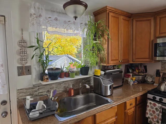 a kitchen with a sink appliances cabinets and a window