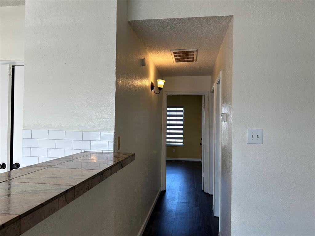 4107 Esters Road Irving, TX 75038 - Photo 10 of 21 Breakfast bar featuring a tiled countertop and white subway tile backsplash