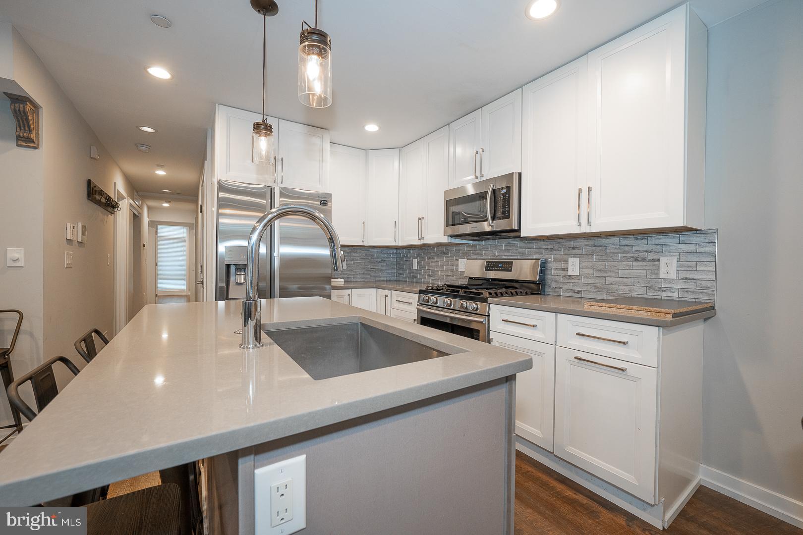 769 North Uber Street, Unit 2 Philadelphia, PA 19130 - Photo 7 of 23 a kitchen with kitchen island a sink stainless steel appliances and cabinets
