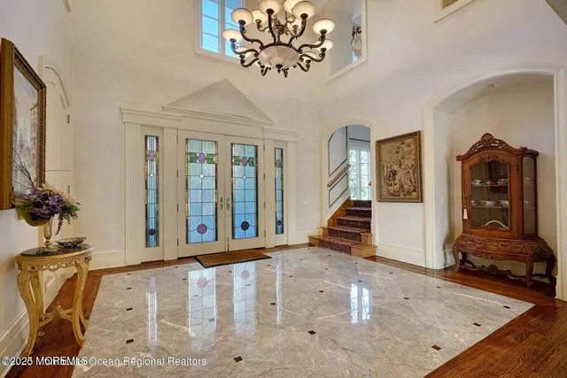 a view of a dining room with furniture a chandelier and wooden floor