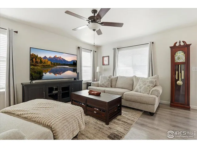 a living room with furniture a flat screen tv and a large window