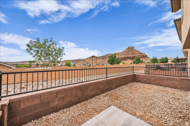 5875 Challenger Way St. George, UT 84790 - Photo 2 of 18 Low-maintenance terraced yard featuring gravel ground cover and an elevated black metal fence