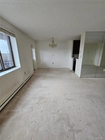 an empty room with a mirror and a ceiling fan