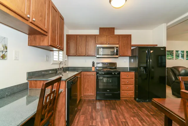 a kitchen with stainless steel appliances granite countertop a refrigerator stove and sink