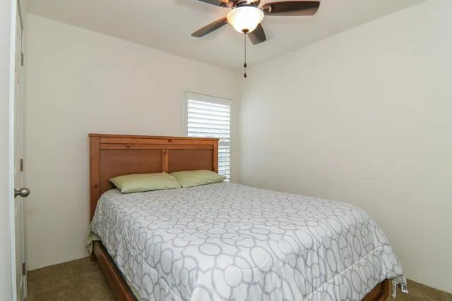 a bedroom with a bed and a chandelier fan