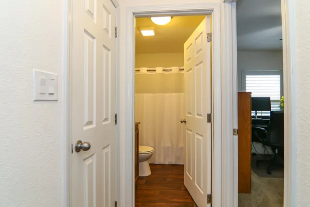 a bathroom with a granite countertop sink toilet and a mirror