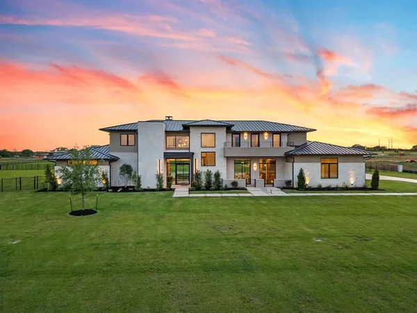 a view of a house with a big yard and large trees